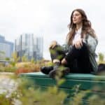 Meditation of an office employee on a park bench in a yoga position against the backdrop of office